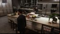 Vampire The Masquerade Swansong review: as Galeb, a vampire in a fine dark suit, the player explores a restaurant kitchen where there's been a recent murder; interaction prompts appear over a white countertop surface laden with crockery and food in the middle of preparation