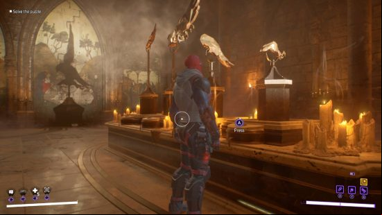 Gotham Knights owl puzzle: Red Hood is looking at four statues and buttons that turn them as a spotlight shines on the mural behind. The parts of the statue cast a shadow on the mural. The chamber is lit with candlelight.