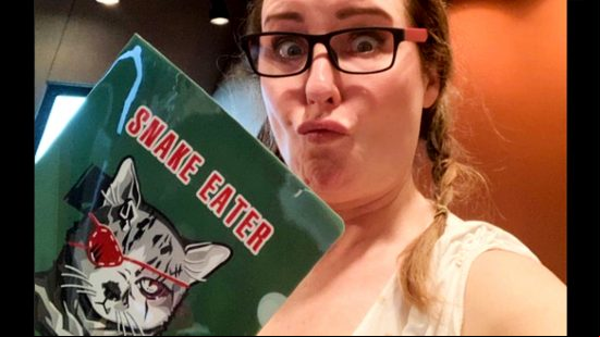 MGS3 - photograph of voice actor Donna Burke holding a 'Snake Eater' picture with a cat dressed as Big Boss