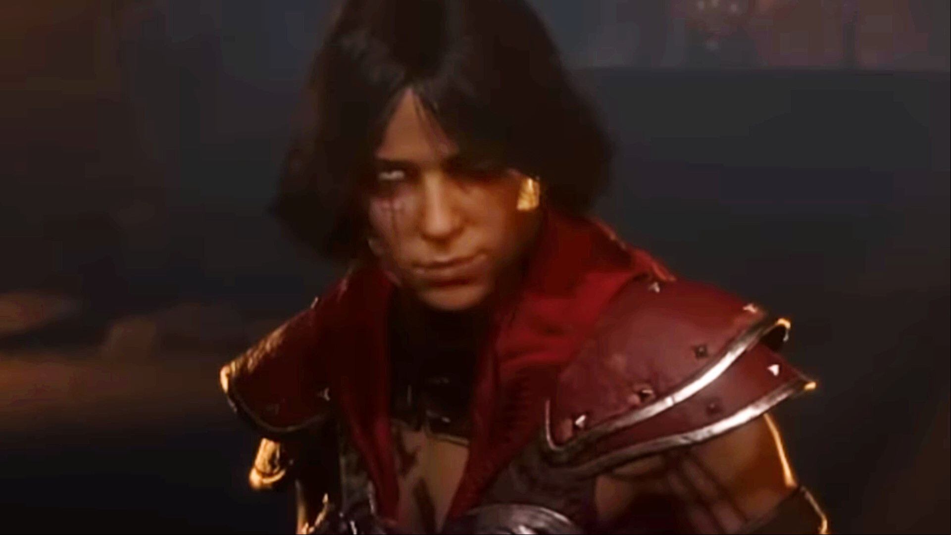A female Diablo 4 rogue wearing red smiles as she looks straight forward