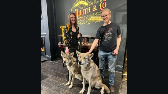 Diablo 4 chocolate shop - PCGamesN staff Lauren and Ken stand with two real-life 'wolves' in the promotional store.