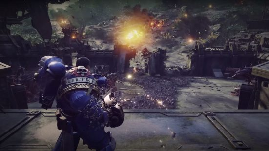 A man in huge blue armor mows down an army of aliens with a machine gun