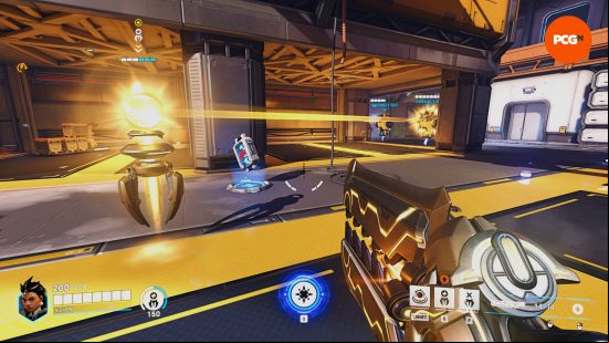 Overwatch 2 Illari - demonstration of her Healing Pylon's range in the training room. The right bot is inside its radius; the left bot sits outside it.