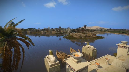 Total War Pharaoh campaign - A town built on the banks of a river. Boats rest at a dock by blazing fire pits.