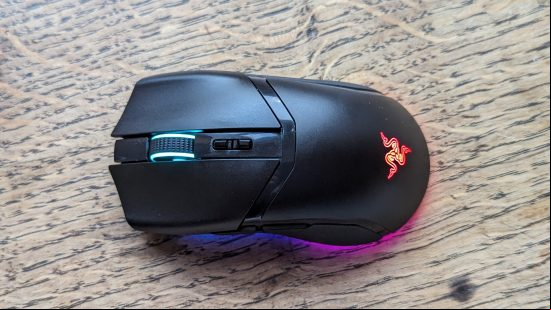 Razer Cobra Pro review: a black mouse with multicolored RGB appears on a wooden surface.