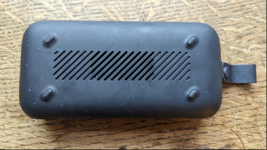 Anker Soundcore Motion 300 review: a black speaker with silver grille appears on a wooden surface.