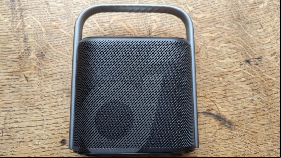 Anker Soundcore Motion X500 review: a black speaker with silver handle appears from above against a wooden surface.