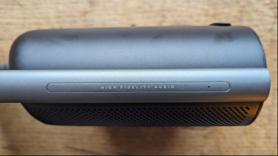 Anker Soundcore Motion X500 review: a black speaker with silver handle appears from the side against a wooden surface.