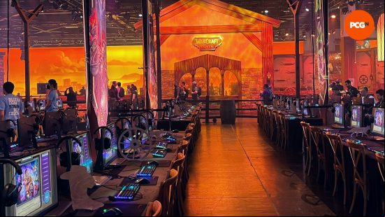 Lots of PCs lined up in a row in front of a wooden structure with a sign that says 'Warcraft'
