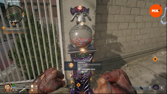 A player clenches there fists as they stand in front of a Black ops 6 Zombies Gobblegum machine.